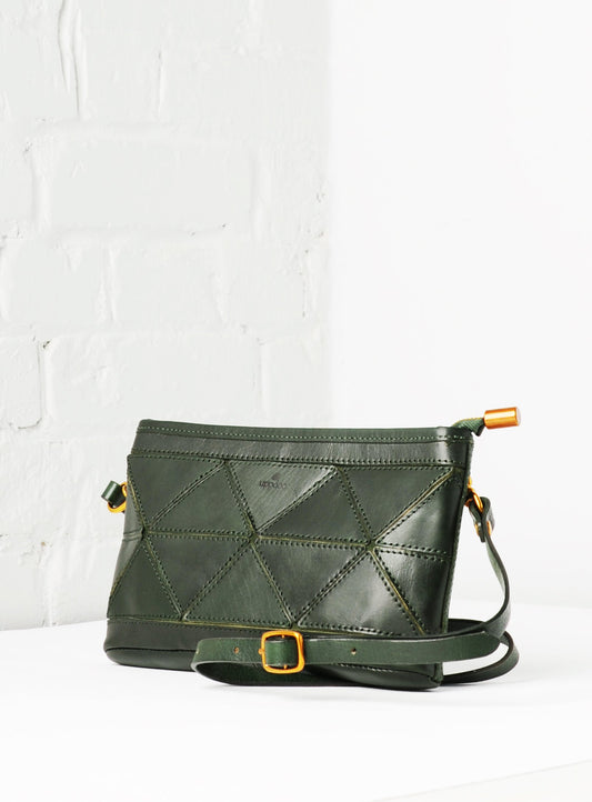 Green leather crossbody bag with geometric pattern on a white background