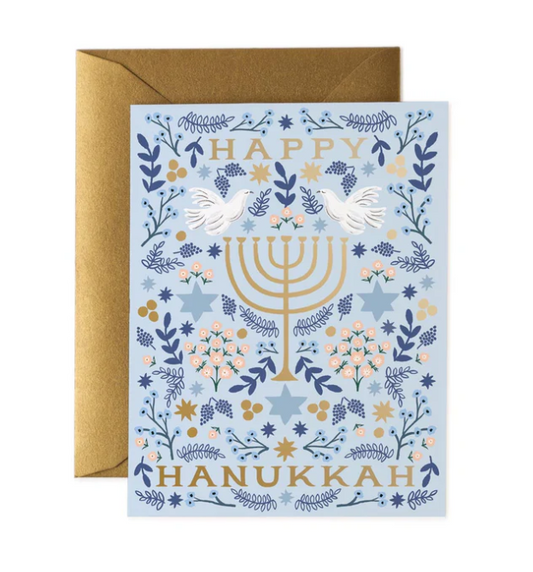 Hanukkah greeting card with Menorah, stars, and flowers on a blue background with gold and white accents.